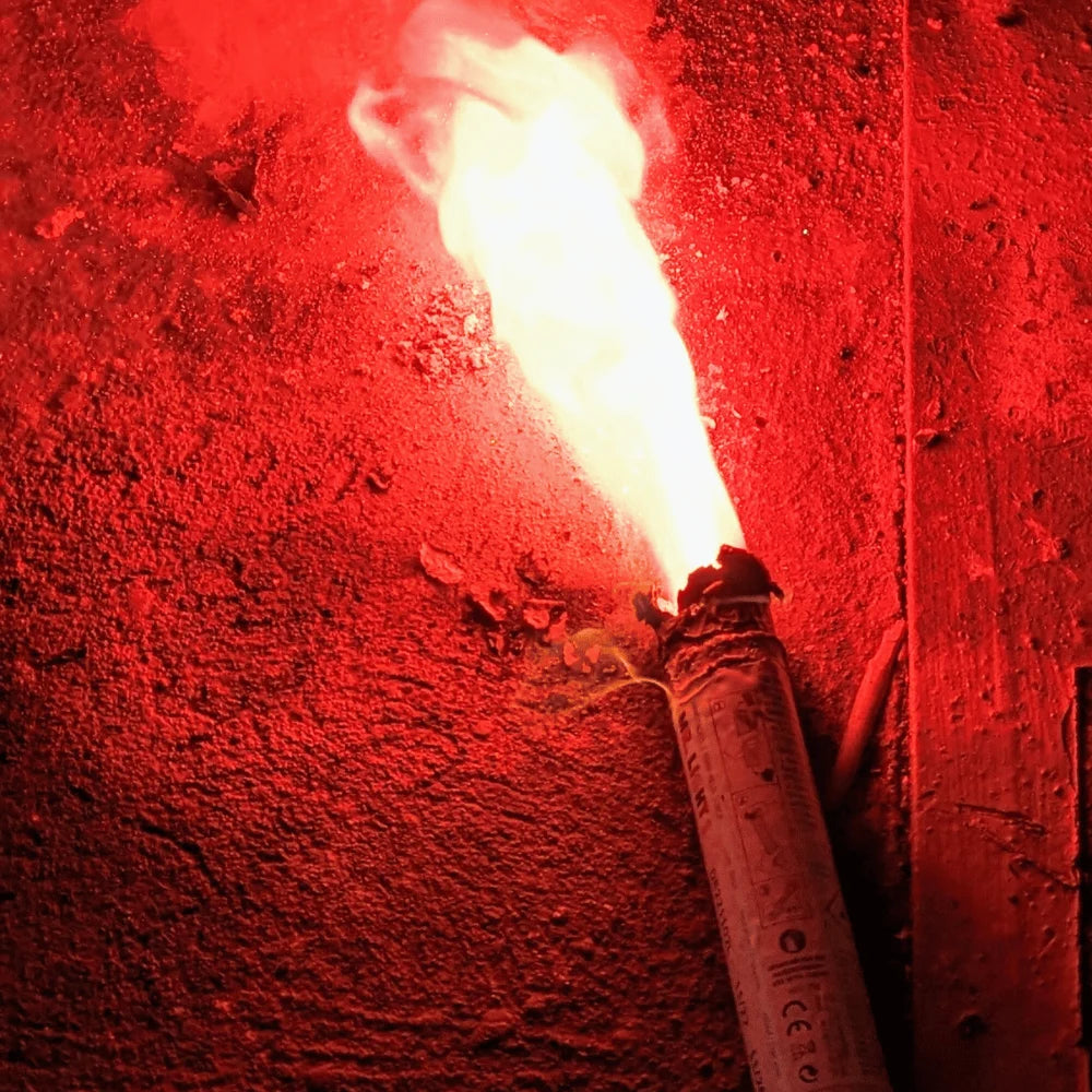 Brennendes, aktives Mr. Light Bengalo in der Farbe rot. Man sieht den intensiven Feuerschein und die Rauchentwicklung eines Bengalos